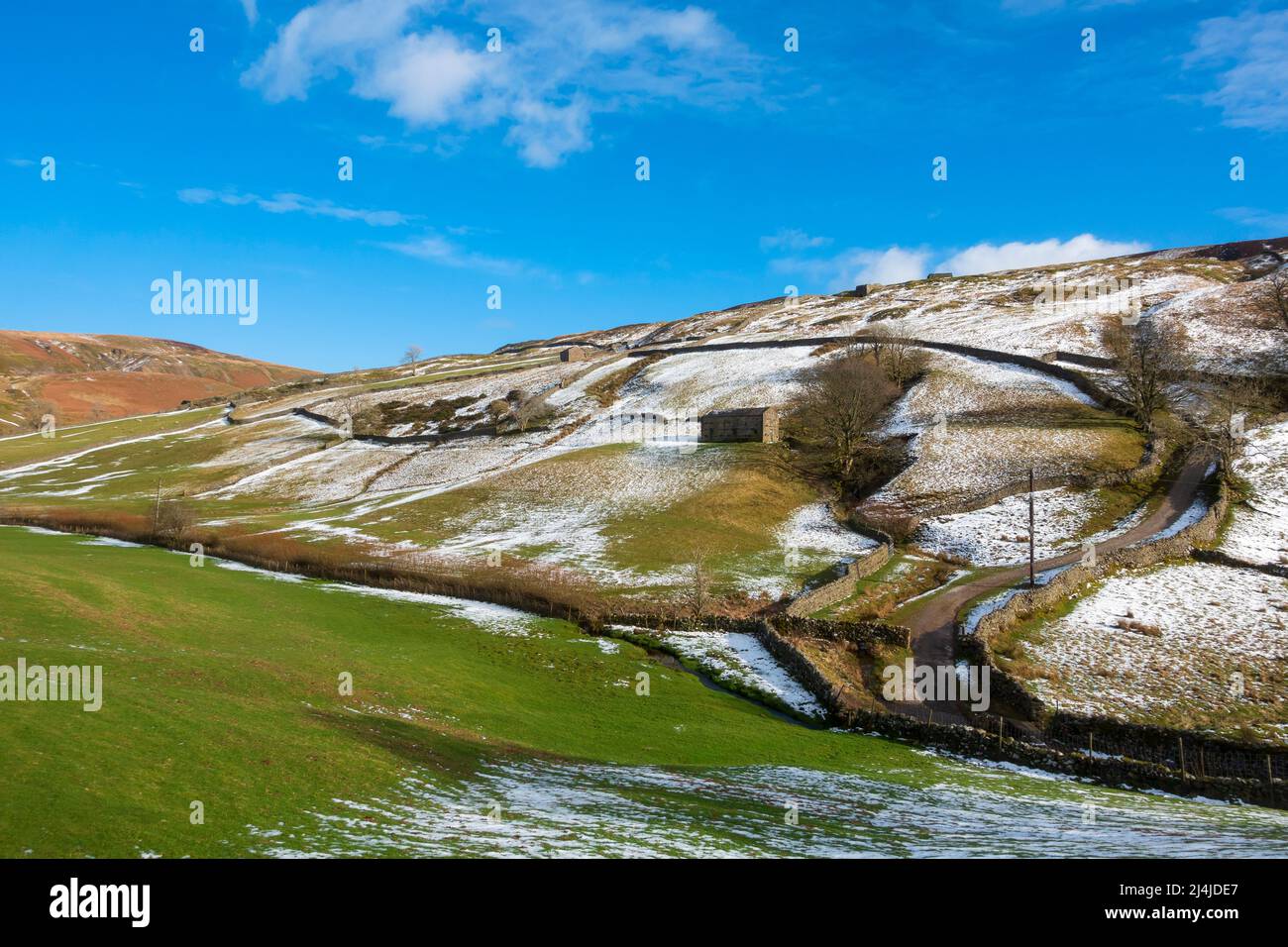 Steinscheune und schneebedeckte Hügel in Swaledale, Yorkshire Dales National Park. Stockfoto