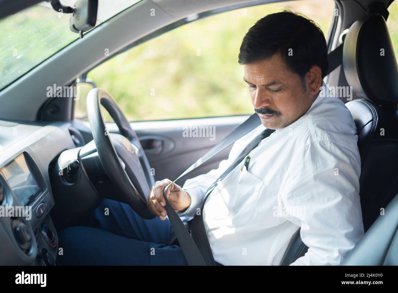 Geschäftsmann, der vor dem Autofahren Sicherheitsgurt angelegt hat – Konzept der Sicherheitsvorkehrungen, des Schutzes und der Verantwortung. Stockfoto