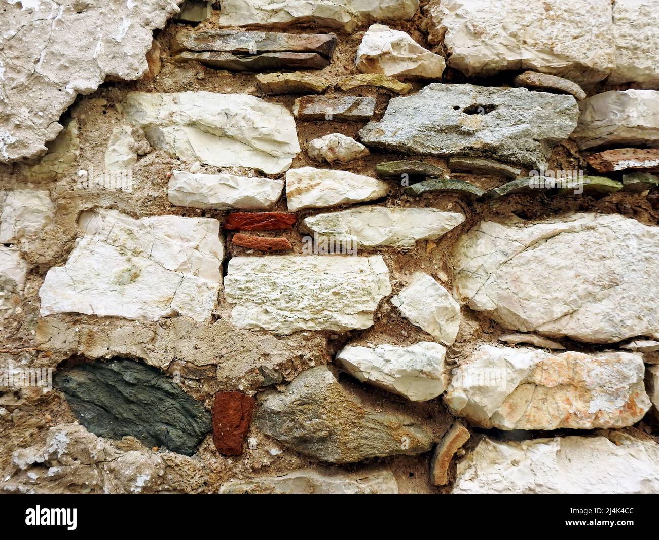 Wand mit verschiedenen Steinen und Dachziegeln gebaut Stockfoto