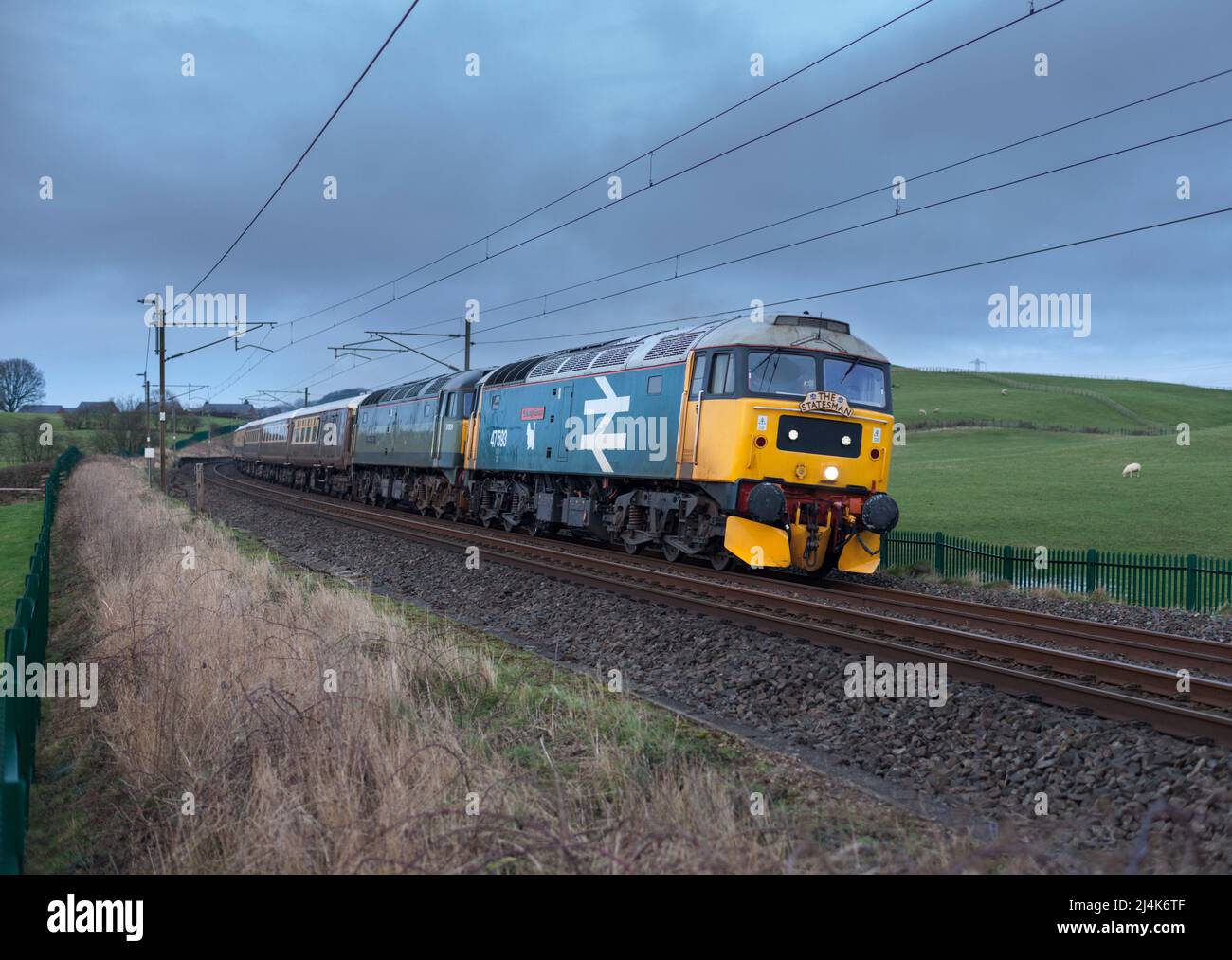 Lokomotivdienste LTD großes Logo blau Lokomotive der Baureihe 47 47593 mit einem Staatsmann-Eisenbahn-Speisecharterzug auf der Hauptlinie der Westküste Stockfoto