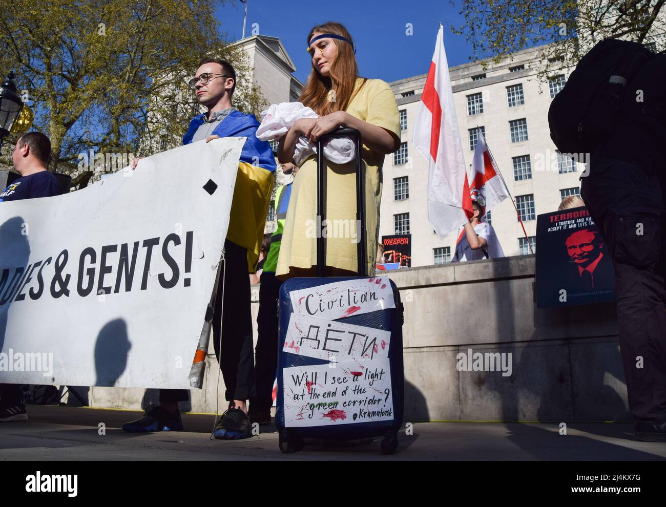 London, Großbritannien. 16.. April 2022.Eine Frau hält ein mit gefälschtem Blut bedecktes Stoffbaby und einen Koffer. Demonstranten versammelten sich in Solidarität mit der Ukraine und stellten vor der Downing Street einen Stapel Gepäck auf, um die Menschen zu symbolisieren, die aus der Ukraine fliehen, während Russland seinen Angriff fortsetzt. Kredit: Vuk Valcic/Alamy Live Nachrichten Stockfoto