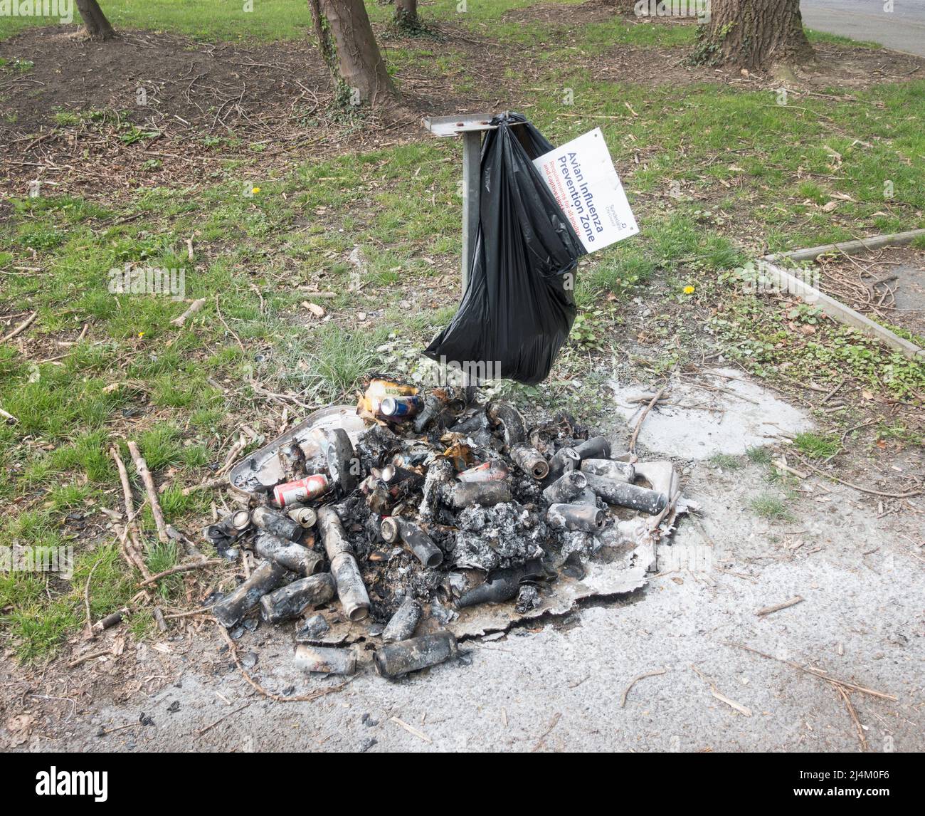 Ein Abfalleimer, der von Vandalen verbrannt wurde und verkohlte Überreste des Inhalts auf dem Boden zurückließ, Washington, Nordostengland, Großbritannien Stockfoto
