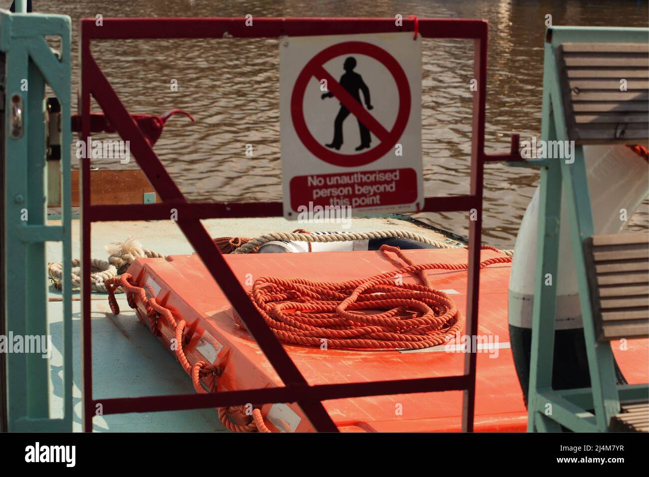 Ein Seil und ein schwebender Boom an Bord eines Bootes auf der Themse und Warnschilder Stockfoto
