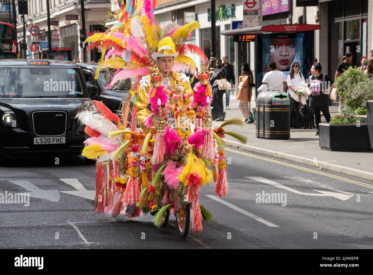 Der extravagante, gefiederte Radfahrer james Bond aus merton wimbledon in der Oxford Street, westminster, london, england Stockfoto