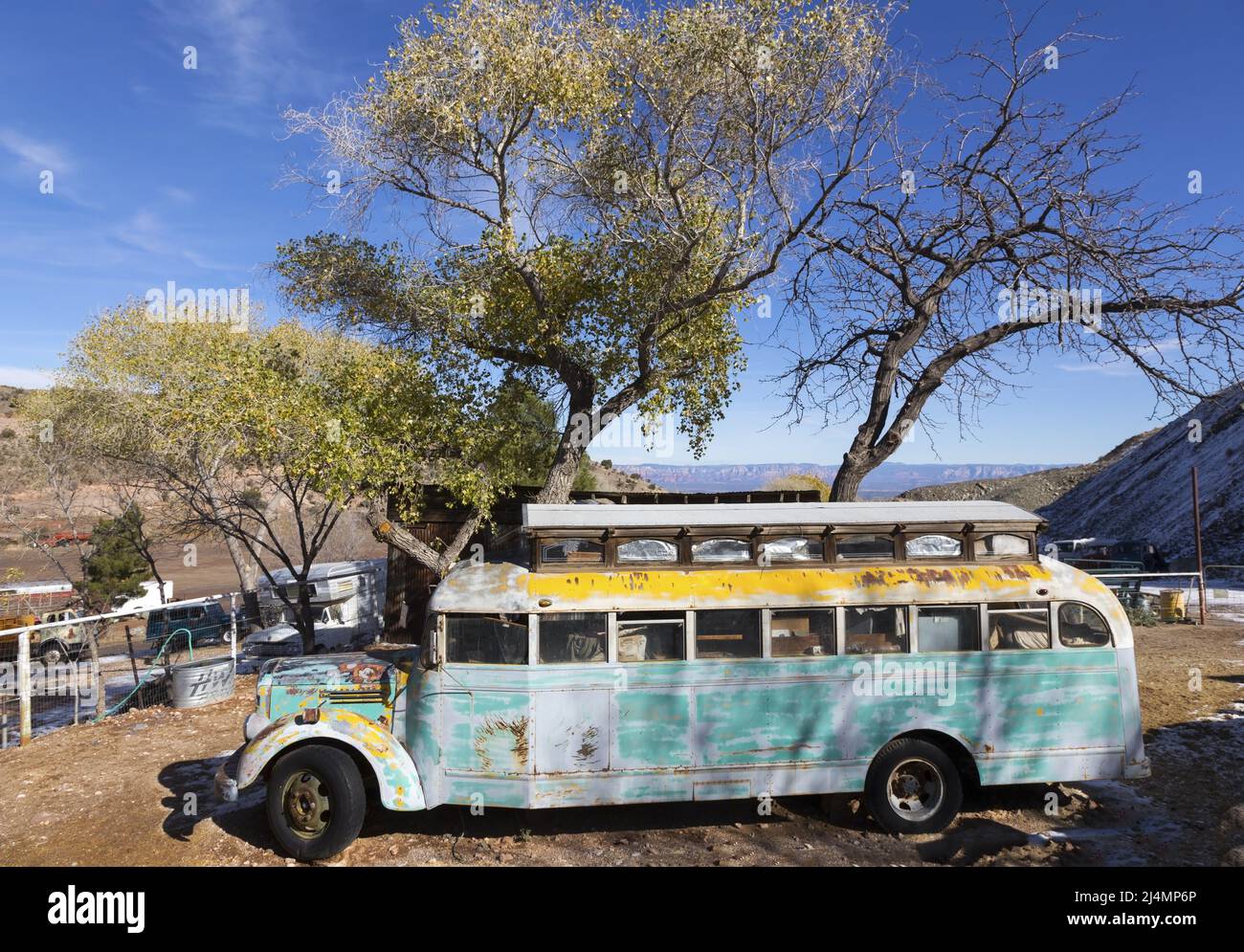 Alter veralteter verlassener Schulbus, der auf dem alten Kesselwagendepot in Jerome, Arizona, rustet Stockfoto