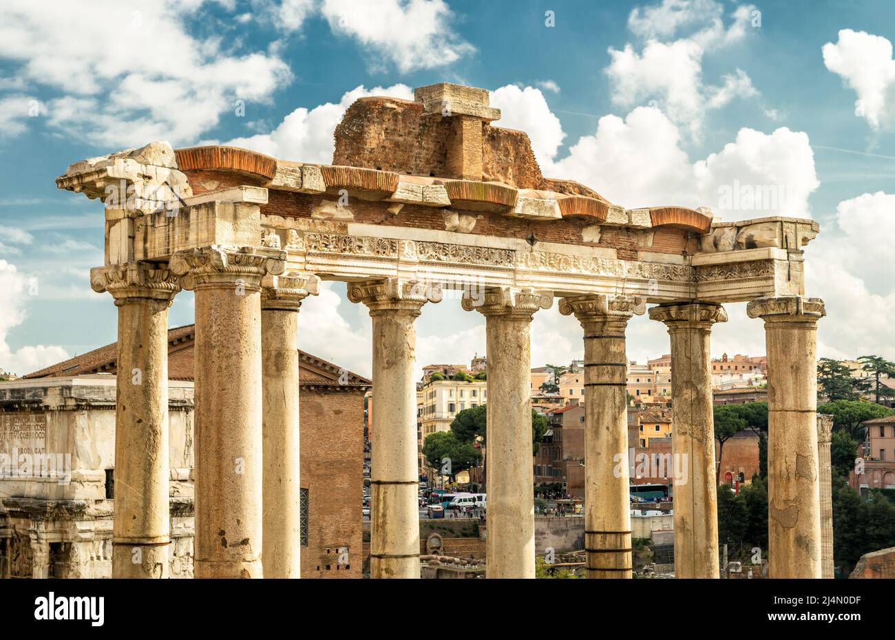 Antiker Saturn-Tempel im Forum Romanum, Rom, Italien, Europa. Es ist das Wahrzeichen Roms. Alte Säulen ragen über die Ruinen des Forums und die Stadtgebäude in Roma Cen Stockfoto