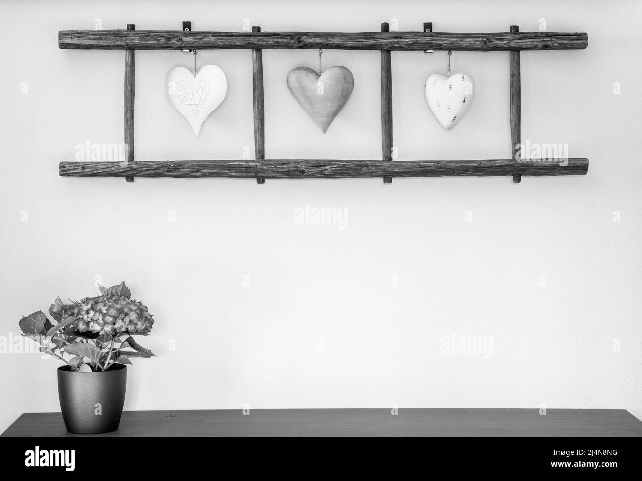 Alte Holzleiter mit Herzen, die an der Wand hängen. Heimtextilien. Stockfoto