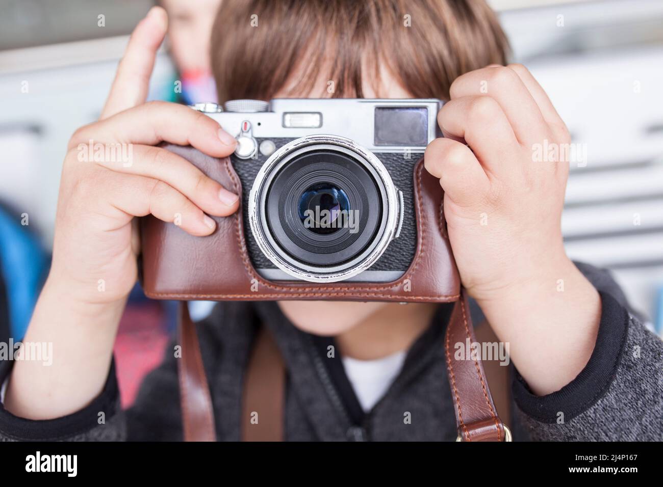 Kind Junge fotografieren mit Retro-Kamera. Er ist dabei, den Auslöser zu drücken Stockfoto