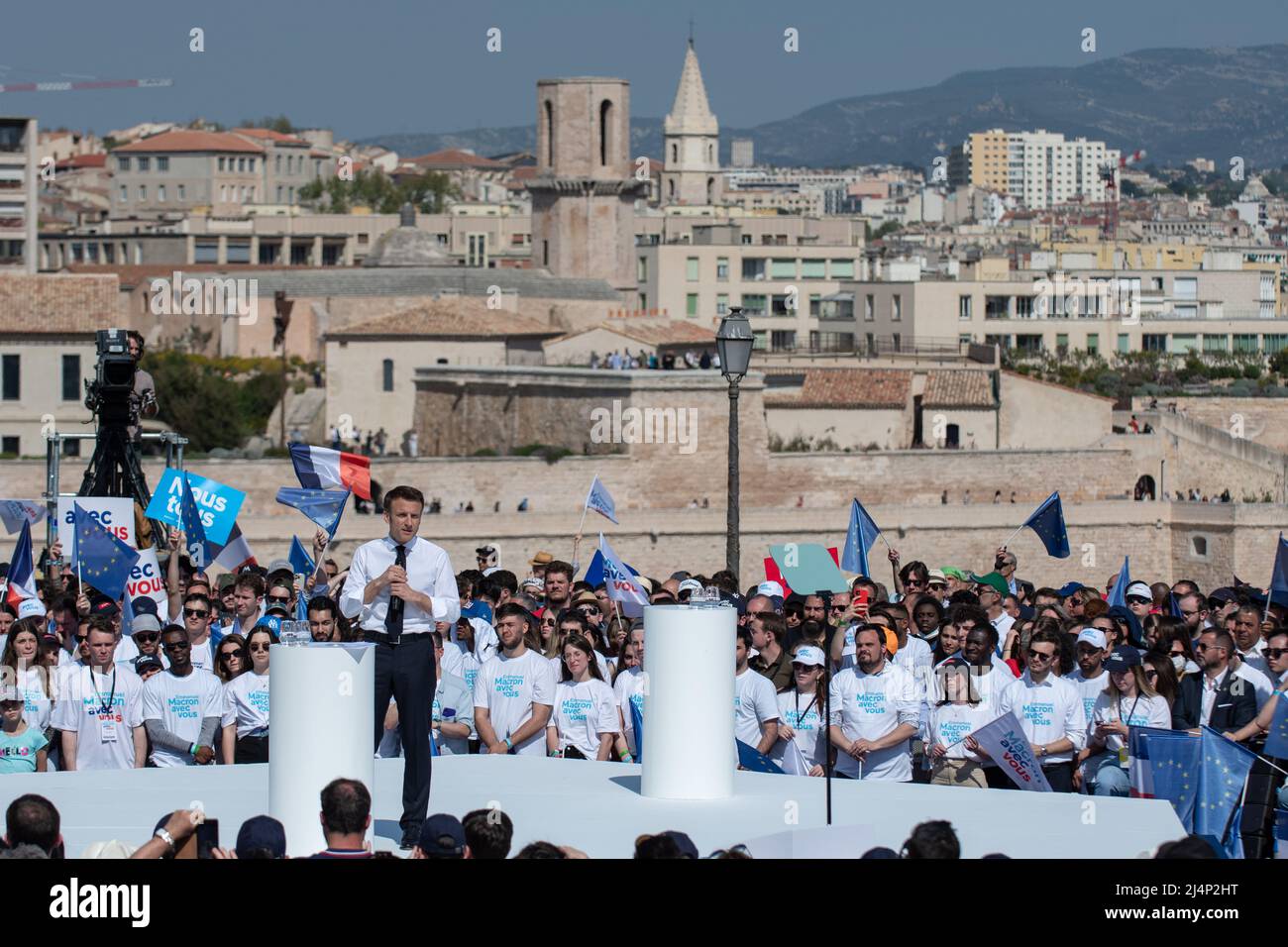 Emmanuel Macron sieht auf der Bühne Reden mit der Stadt Marseille im Hintergrund. Emmanuel Macron ist in Marseille zu einem Treffen der zweiten Runde der Präsidentschaftswahlen, das ihn am 24. April 2022 gegen Marine Le Pen stellt. Er muss die Stimme der Wähler anziehen, die sich für Jean-Luc Mélenchon entschieden haben (radikale ökologische Sensibilität der Linken). Er kündigte starke Auswirkungen seiner künftigen Politik im Hinblick auf den Umweltschutz und die Bedeutung der Jugend für die Entscheidungen an, die getroffen werden, wenn er erneut gewählt wird. Er rief auch dazu auf, seinen Gegner von der extremen Rechten zu schlagen Stockfoto