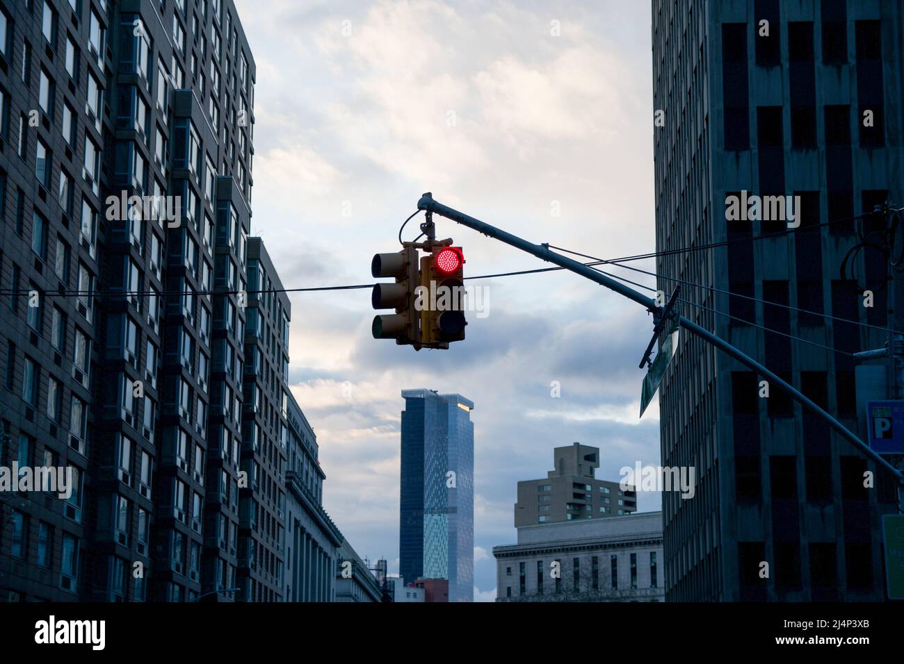 Über einem Hochhaus in Manhattan, New York City, scheint eine rote Ampel zu hängen. Dunkle Atmosphäre am frühen Morgen Stockfoto