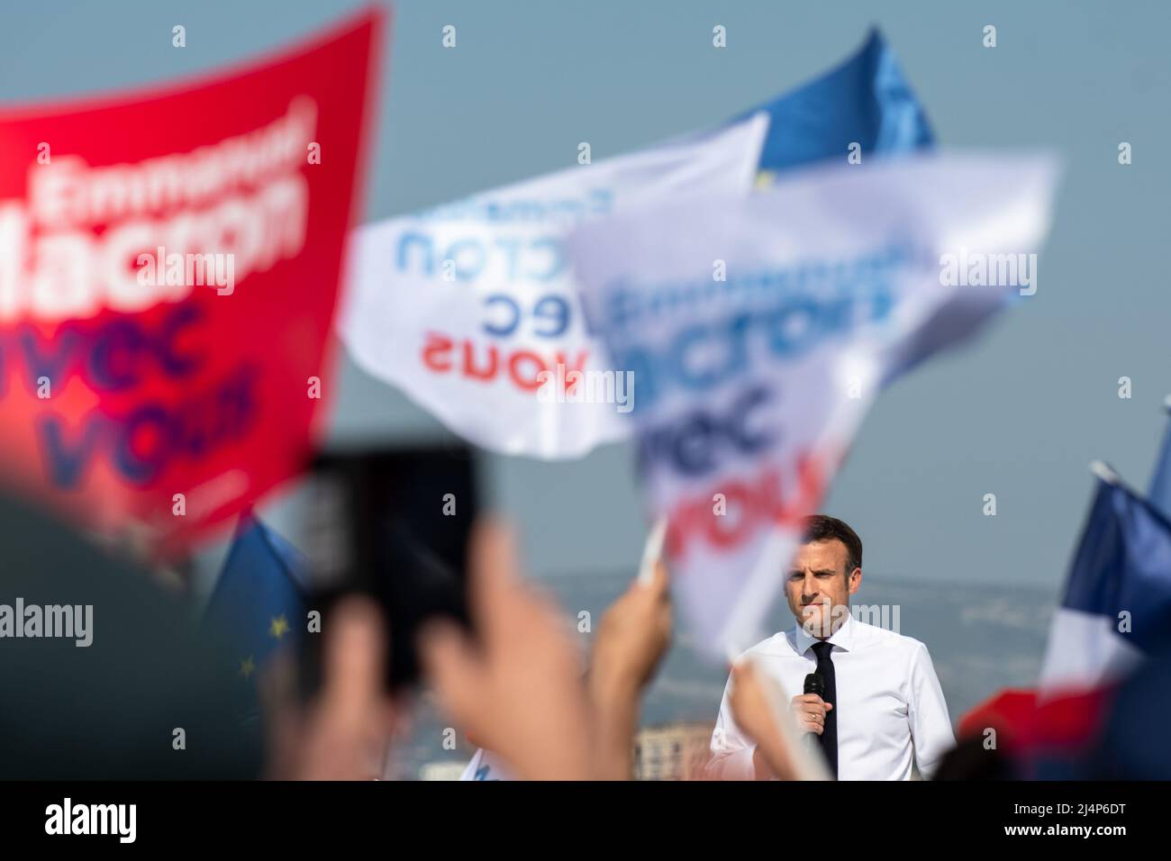 Emmanuel Macron sah auf der Bühne Reden halten, umgeben von Flaggen, die von seinen Anhängern geschwenkt wurden. Emmanuel Macron ist in Marseille zu einem Treffen der zweiten Runde der Präsidentschaftswahlen, das ihn am 24. April 2022 gegen Marine Le Pen stellt. Er muss die Stimme der Wähler anziehen, die sich für Jean-Luc Mélenchon entschieden haben (radikale ökologische Sensibilität der Linken). Er kündigte starke Auswirkungen seiner künftigen Politik im Hinblick auf den Umweltschutz und die Bedeutung der Jugend für die Entscheidungen an, die getroffen werden, wenn er erneut gewählt wird. Er rief auch dazu auf, seinen Gegner von der extremen Rechten zu schlagen Stockfoto