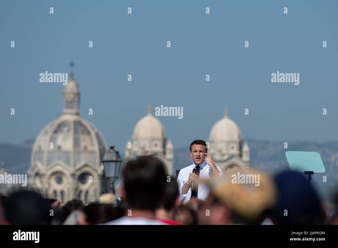 Emmanuel Macron sieht auf der Bühne Reden mit der Kathedrale des Majors von Marseille im Hintergrund. Emmanuel Macron ist in Marseille zu einem Treffen der zweiten Runde der Präsidentschaftswahlen, das ihn am 24. April 2022 gegen Marine Le Pen stellt. Er muss die Stimme der Wähler anziehen, die sich für Jean-Luc Mélenchon entschieden haben (radikale ökologische Sensibilität der Linken). Er kündigte starke Auswirkungen seiner künftigen Politik im Hinblick auf den Umweltschutz und die Bedeutung der Jugend für die Entscheidungen an, die getroffen werden, wenn er erneut gewählt wird. Er rief auch an, seinen Gegner von der zu schlagen Stockfoto