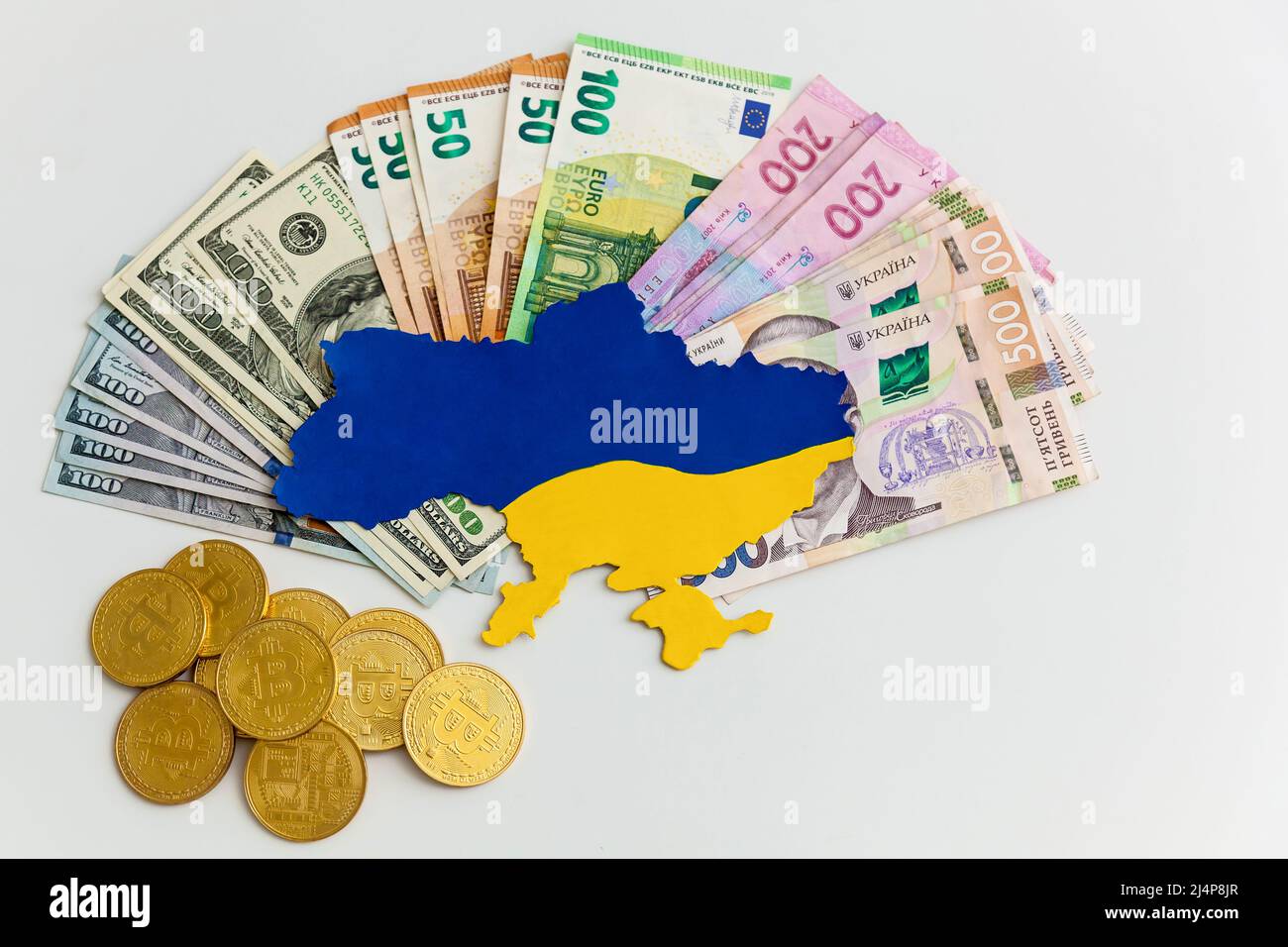 Die in Blau und Gelb gestrichene Landkarte der Ukraine liegt auf Geldscheinen, Dollars, Euros und Griwna auf weißem Grund. Hilfe von westlichen Partnern im Stockfoto