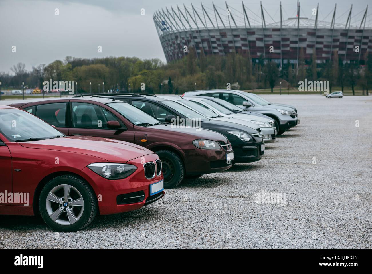 Autos in einer Reihe geparkt. Der Parkplatz ist mit Kieselsteinen gepflastert. Stockfoto Autos in einer Reihe geparkt. Der Parkplatz ist mit Kieselsteinen gepflastert. Stockfoto
