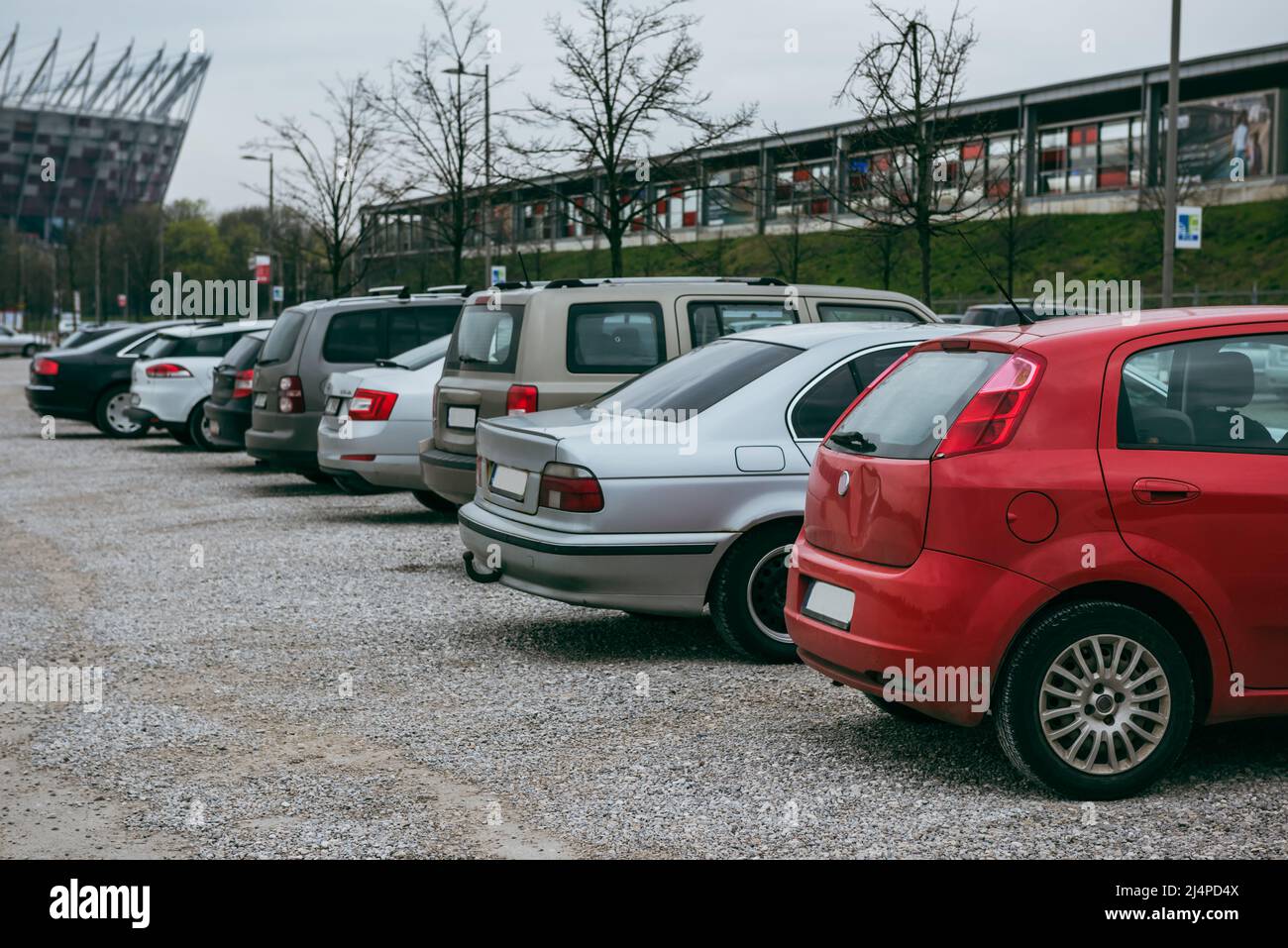 Autos in einer Reihe geparkt. Der Parkplatz ist mit Kieselsteinen gepflastert. Stockfoto Autos in einer Reihe geparkt. Der Parkplatz ist mit Kieselsteinen gepflastert. Stockfoto