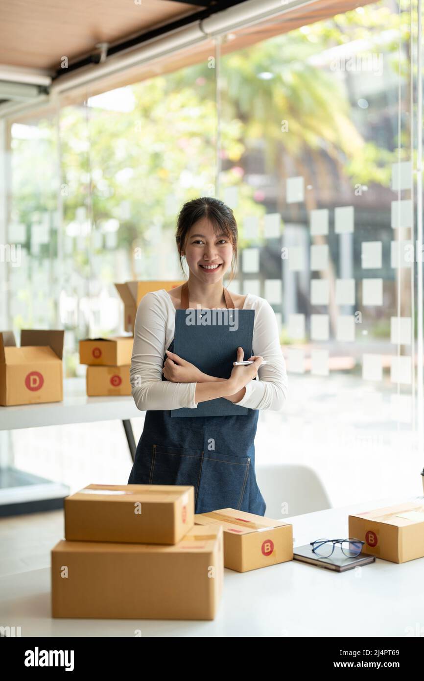 Porträt einer asiatischen jungen Frau KMU, die zu Hause mit einer Box arbeitet der Arbeitsplatz.Start-up Kleinunternehmer, Kleinunternehmer KMU oder Freiberufler Stockfoto