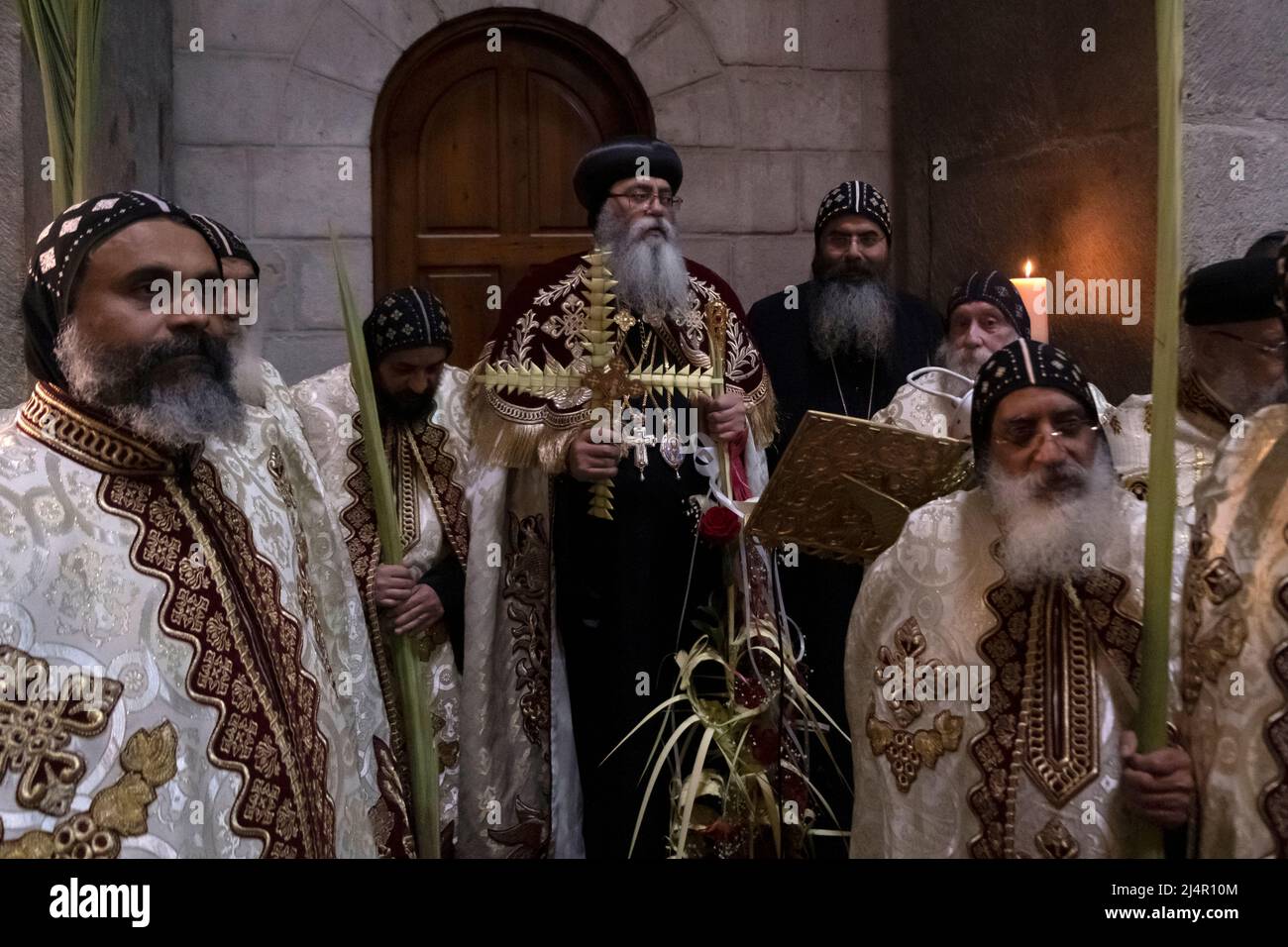 Bischof Anba Antonious der koptische Metropolit von Jerusalem und dem Nahen Osten von 22. hält ein Kreuz aus gewebten Palmen Verlässt, wie er mit anderen koptischen orthodoxen Priestern einen Gottesdienst während des Lazarus-Samstags führt, der die Aufzucht feiert Lazarus von Bethanien in der Grabeskirche in der Altstadt von Jerusalem Israel Stockfoto