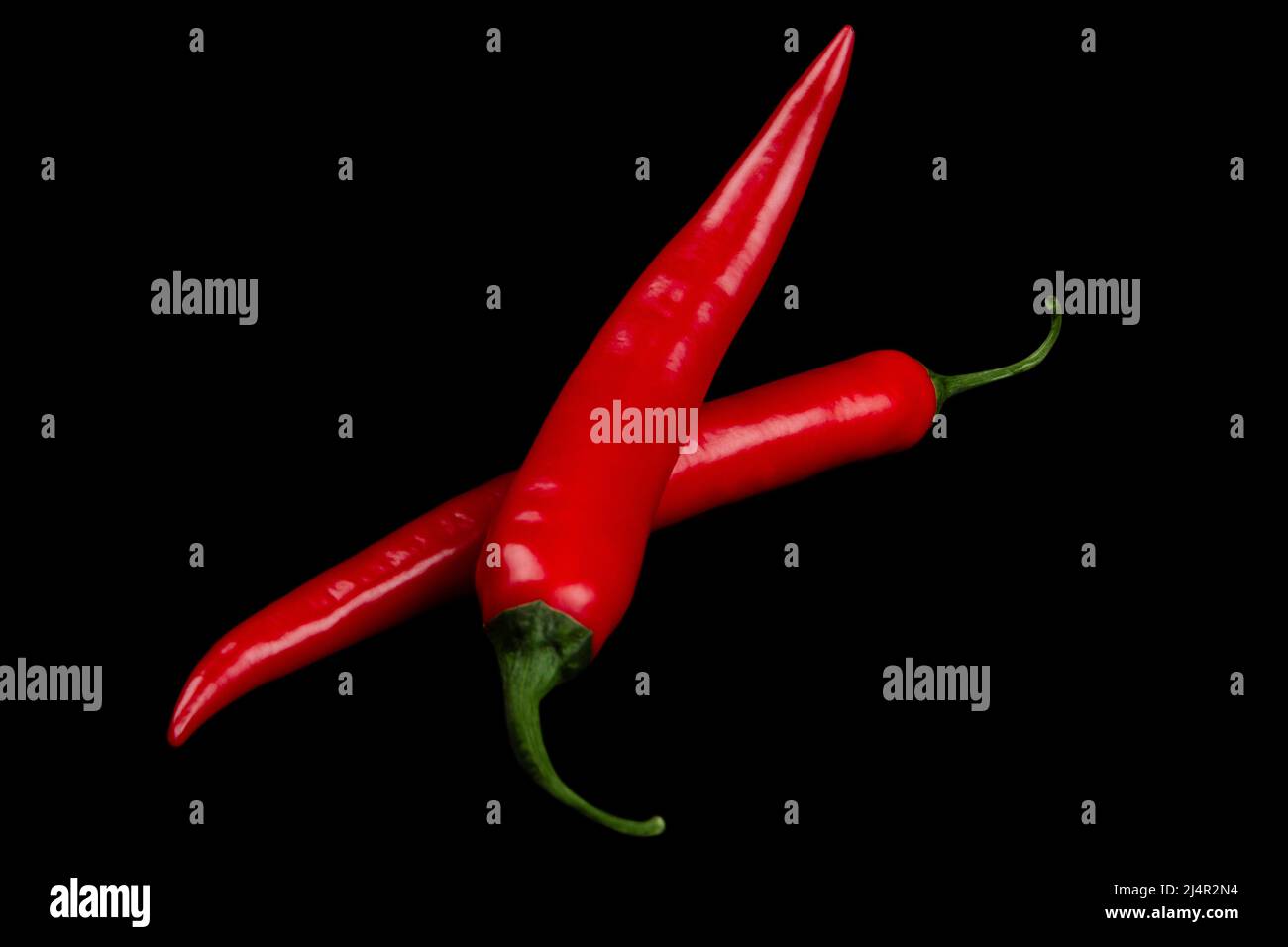 Zwei rote Chilischoten auf schwarzem Hintergrund isoliert Stockfoto