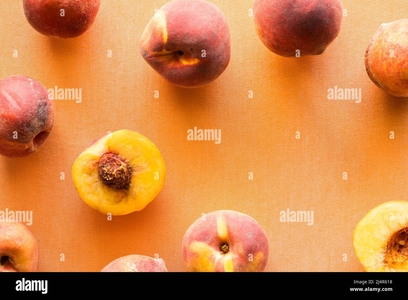 Frische reife Pfirsiche vor hellem Pfirsich-Hintergrund. Stockfoto