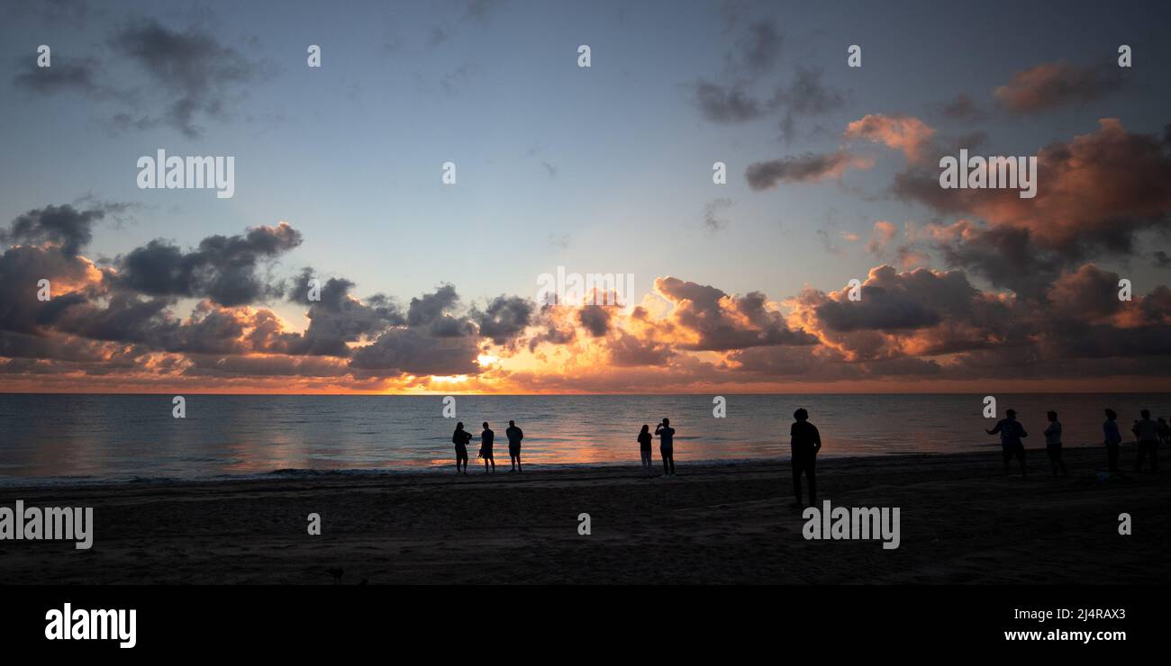 Die Menschen beobachten den Sonnenaufgang am Strand in Delray Beach, Florida. Stockfoto