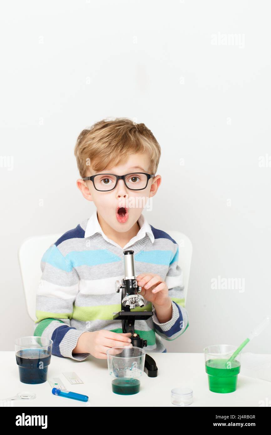 Junge, fünf Jahre alt, experimentierte mit farbigen Flüssigkeiten. Chemische Experimente eines kleinen Wissenschaftlers mit europäischem Aussehen. Stockfoto