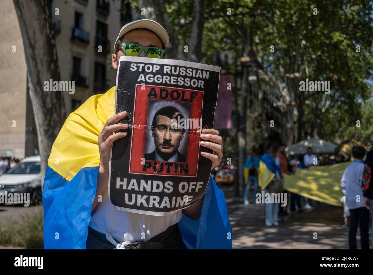 Barcelona, Spanien. 17. April 2022. Ein Protestler zeigt ein Plakat mit einem Bild des russischen Präsidenten Wladimir Putin, das während der Demonstration als Hitler karikiert wurde. Hunderte von Ukrainern mit Wohnsitz in Barcelona haben im Zentrum von Barcelona demonstriert, um ihre Unterstützung für den Widerstand der ukrainischen Bevölkerung zu zeigen. (Foto von Paco Freire/SOPA Images/Sipa USA) Quelle: SIPA USA/Alamy Live News Stockfoto