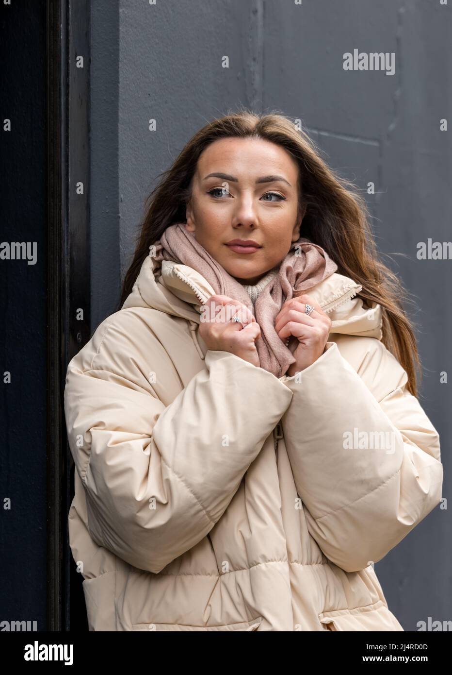 Eine hübsche junge Frau oder ein Model, die eine Winterjacke trägt und in einer Straße posiert, Edinburgh, Schottland, Großbritannien Stockfoto