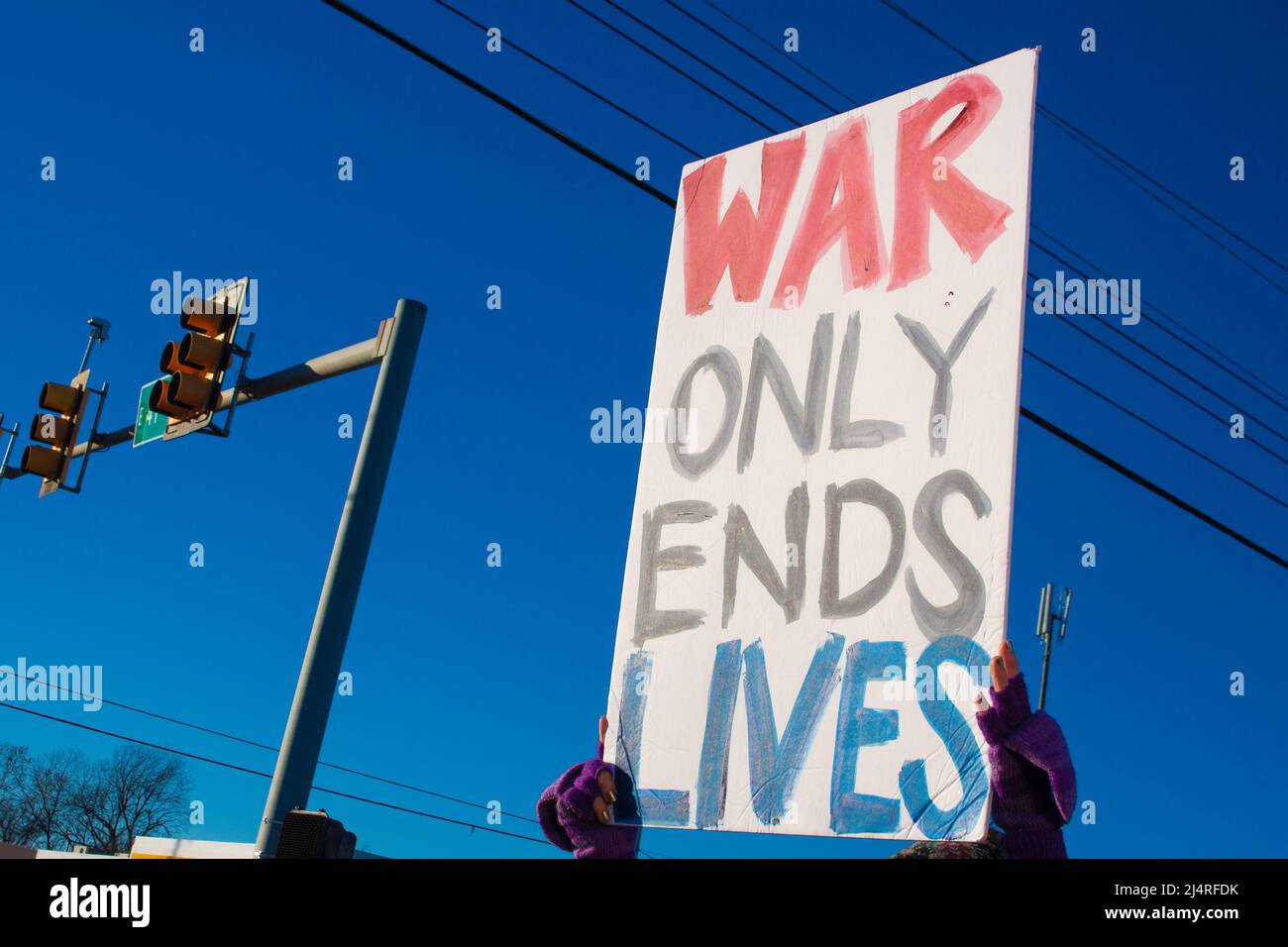Der Protestler, der die Hand hochhielt, machte ein Schild, das sagte, dass Krieg nur bei einer Kundgebung im Freien das Leben beendet Stockfoto