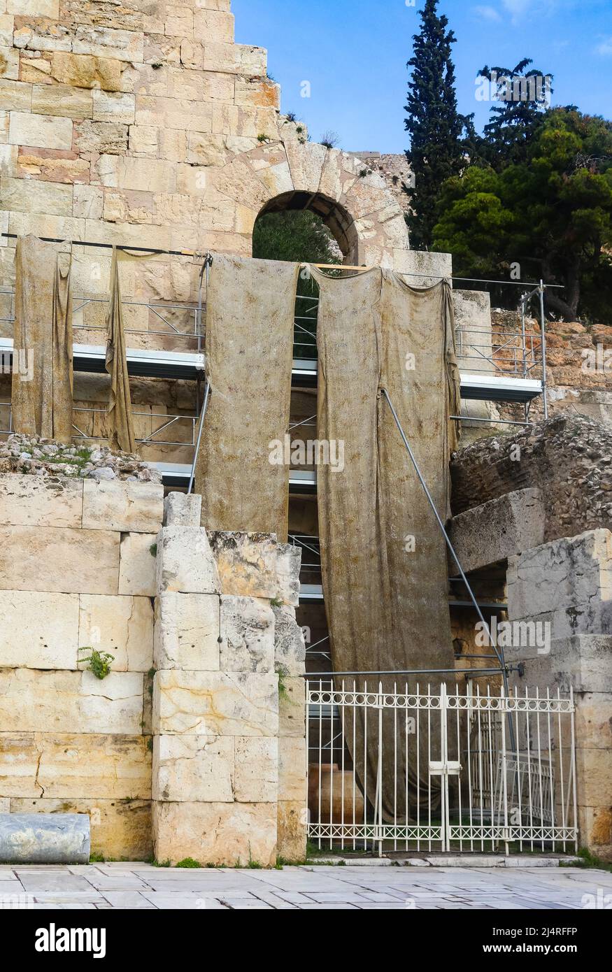 Rekonstruktion des Odeons von Herodes Atticus in der Nähe der Akropolis von Athen mit nassen schmutzigen Stoffschwaden, die vom Gerüst hinter einem Eisen hängen Stockfoto