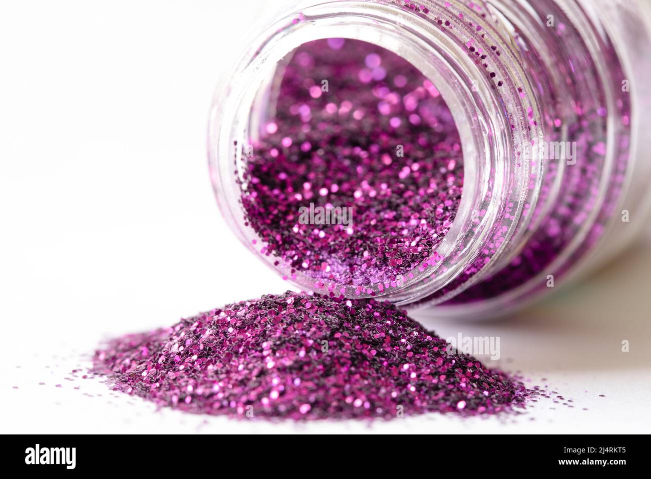 Purpurner Glitter aus einem Glas verschüttet Stockfoto