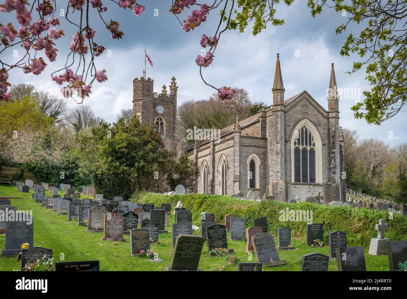An einem geschäftigen Ostersonntag im Küstendorf Appledore bietet der Kirchhof von St. Mary's einen ruhigen Ort für einen Besuch, umgeben von Frühlingsblumen Stockfoto