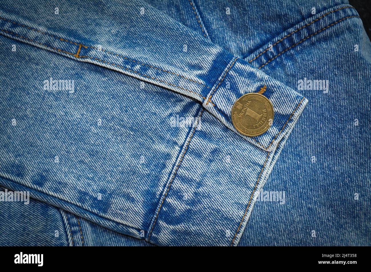 Teil der Jeansjacke mit goldenen Münz-Manschettenknöpfen und Knöpfen Stockfoto