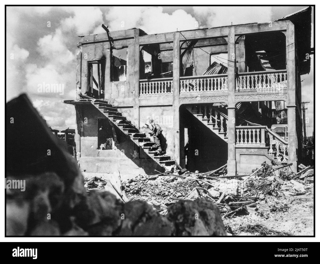 WW2 Schlacht von Guam Ein Marine der Dritten Marine Division geht Haus zu Haus Clearing nach einem japanischen Scharfschützen in einem geschälten Gebäude. Guam, August 1944 Zweiten Weltkrieg Zweiten Weltkrieg Stockfoto