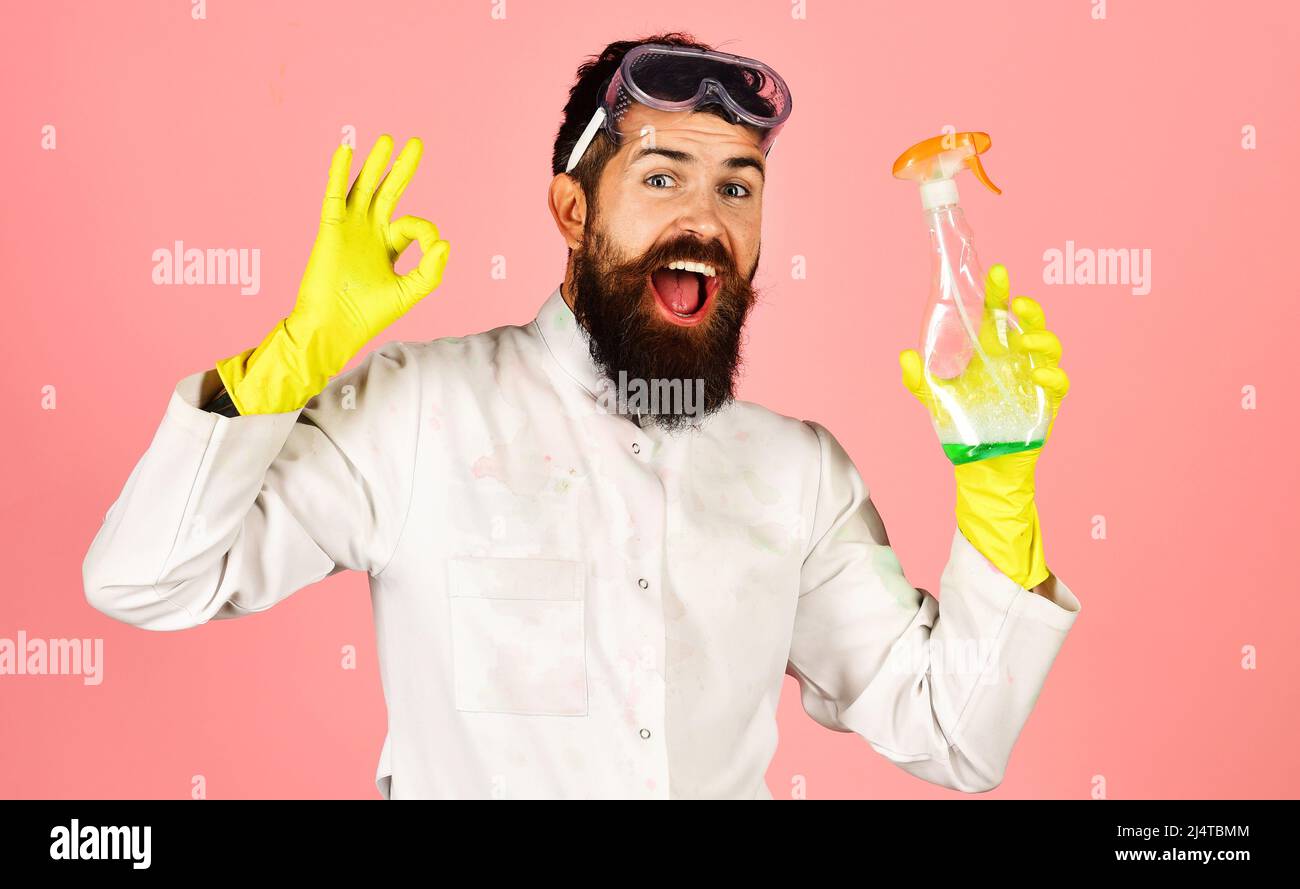 Professioneller Reinigungsdienst-Mann in Schutzhandschuhen mit Reinigungsspray-Flasche mit Schild ok Stockfoto