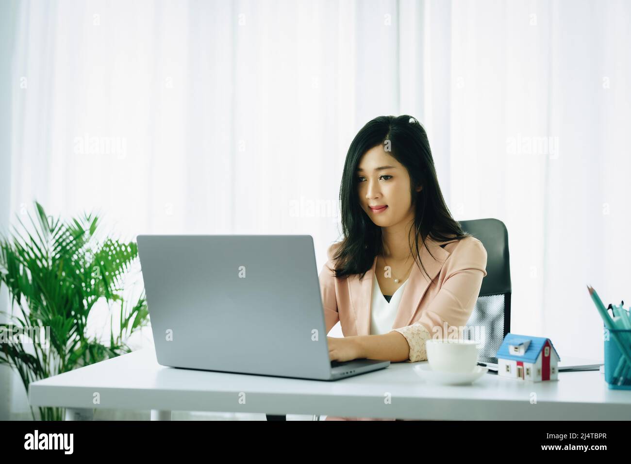 Unternehmer, Unternehmer, Buchhalter, Immobilienmakler, Porträt von asiatischen Frauen mit Computer zu berechnen, um finanzielle Risiken zu kaufen bewerten Stockfoto