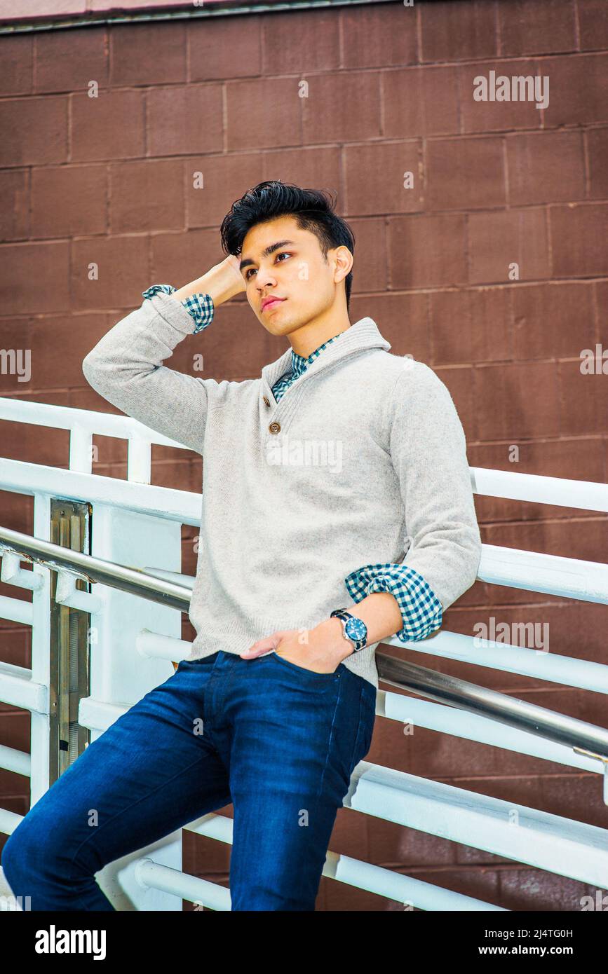 Mann, Miss Dich. In hellgrauem, gekleidtem Pullover mit Schalkragen, Cardigan, blauer Jeans, einem kratzenden Kopf der Hand, einer Hand in der Tasche, ist ein junger Mann s Stockfoto Mann, Miss Dich. In hellgrauem, gekleidtem Pullover mit Schalkragen, Cardigan, blauer Jeans, einem kratzenden Kopf der Hand, einer Hand in der Tasche, ist ein junger Mann s Stockfoto