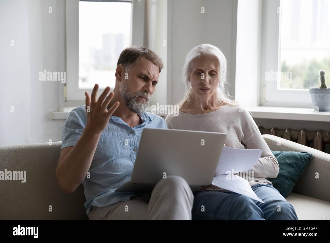 Ein älteres Paar, das die Ausgaben überprüft, sieht genervt aus, da die Versorgungsleistungen steigen Stockfoto