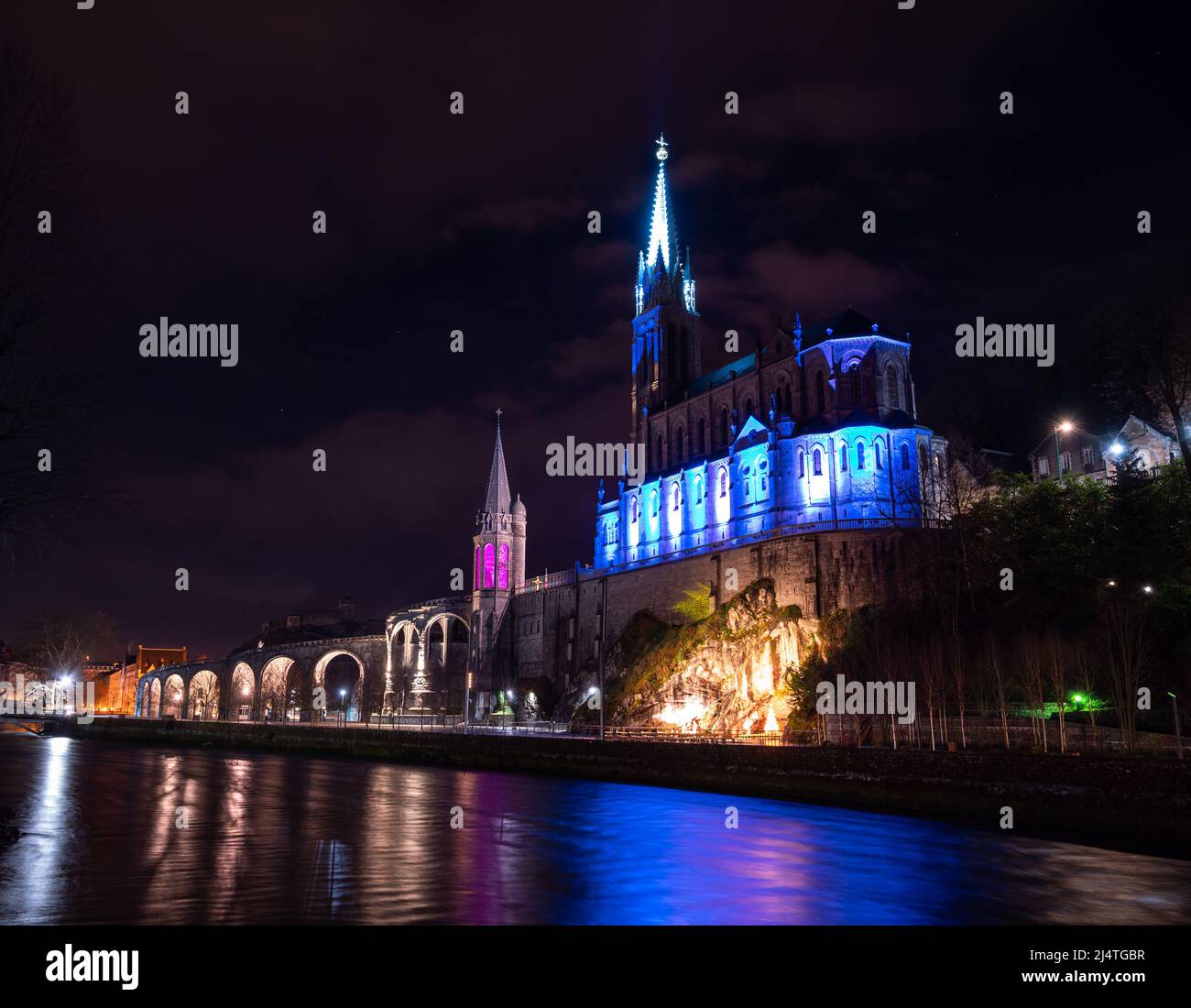 Wallfahrtsbasilika in Lourdes, nachts beleuchtet mit festlicher weihnachtlicher, farbenfroher Beleuchtung Stockfoto