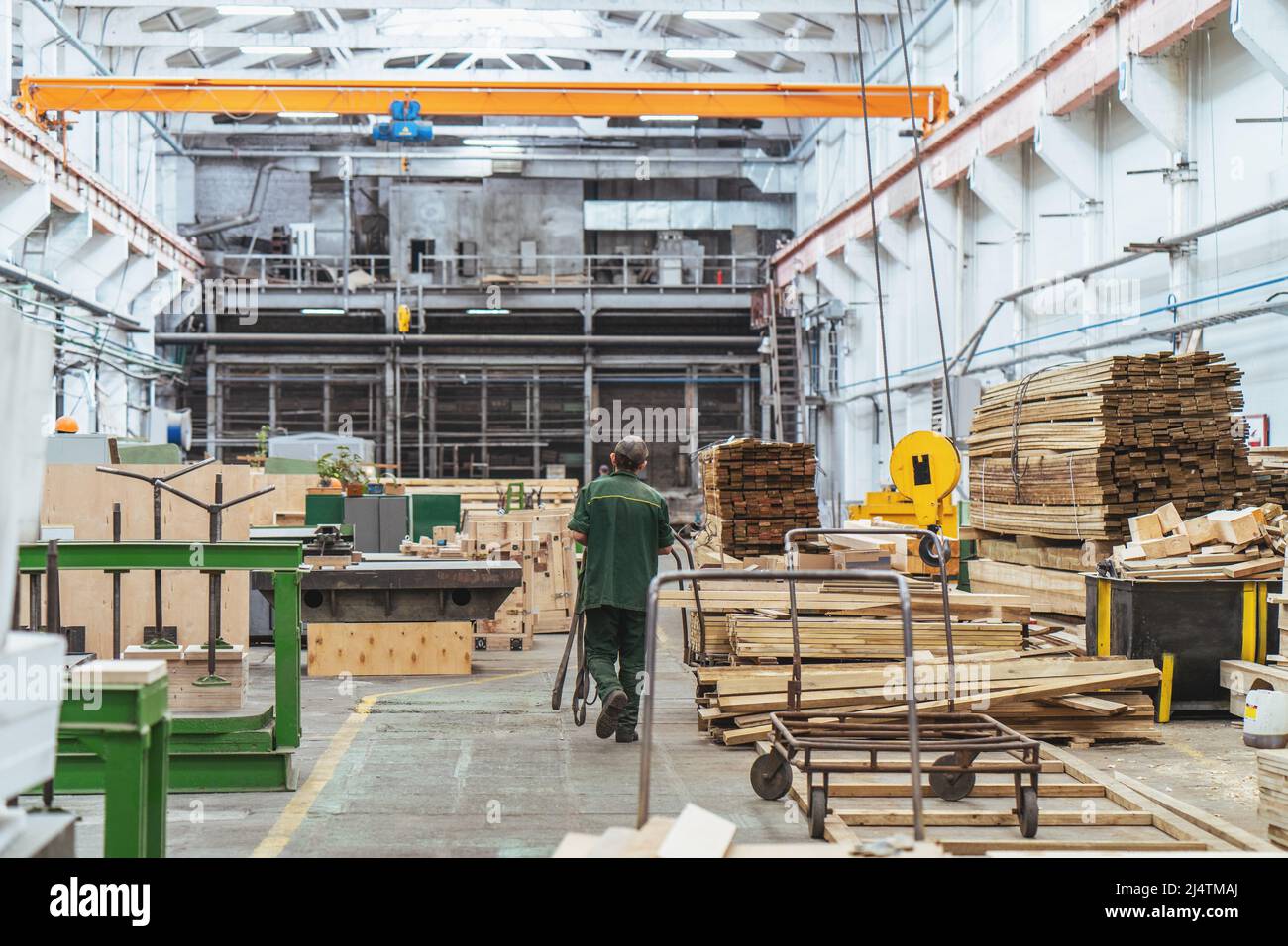 Holzarbeiter in der Fabrik mit Holzstapel. Stockfoto