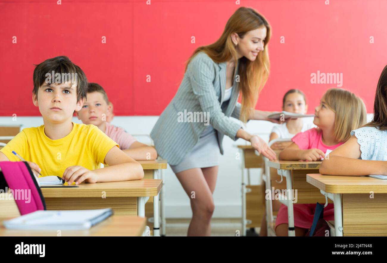 Fleißiger Jugendlicher, der mit Klassenkameraden in der Schule studiert Stockfoto
