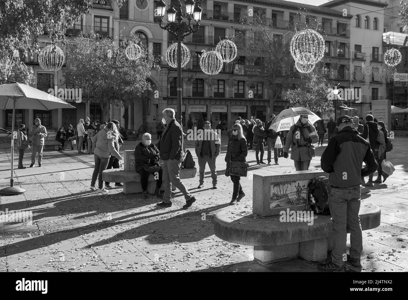 Touristen im Zentrum der Plaza Zocodover und eine Person mit einem orangefarbenen Schirm, die Führungen in der Stadt Toledo, Spanien, Europa ankündigt Stockfoto