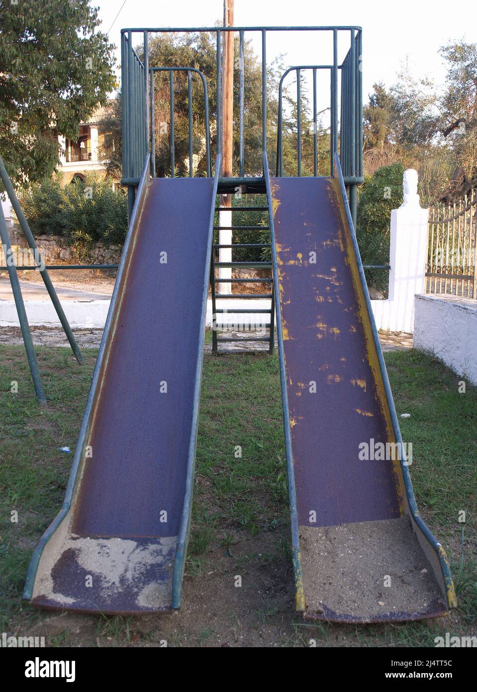 Gut abgenutzte Kinderrutsche auf dem Spielplatz in Xanthates, Korfu, Griechenland Stockfoto