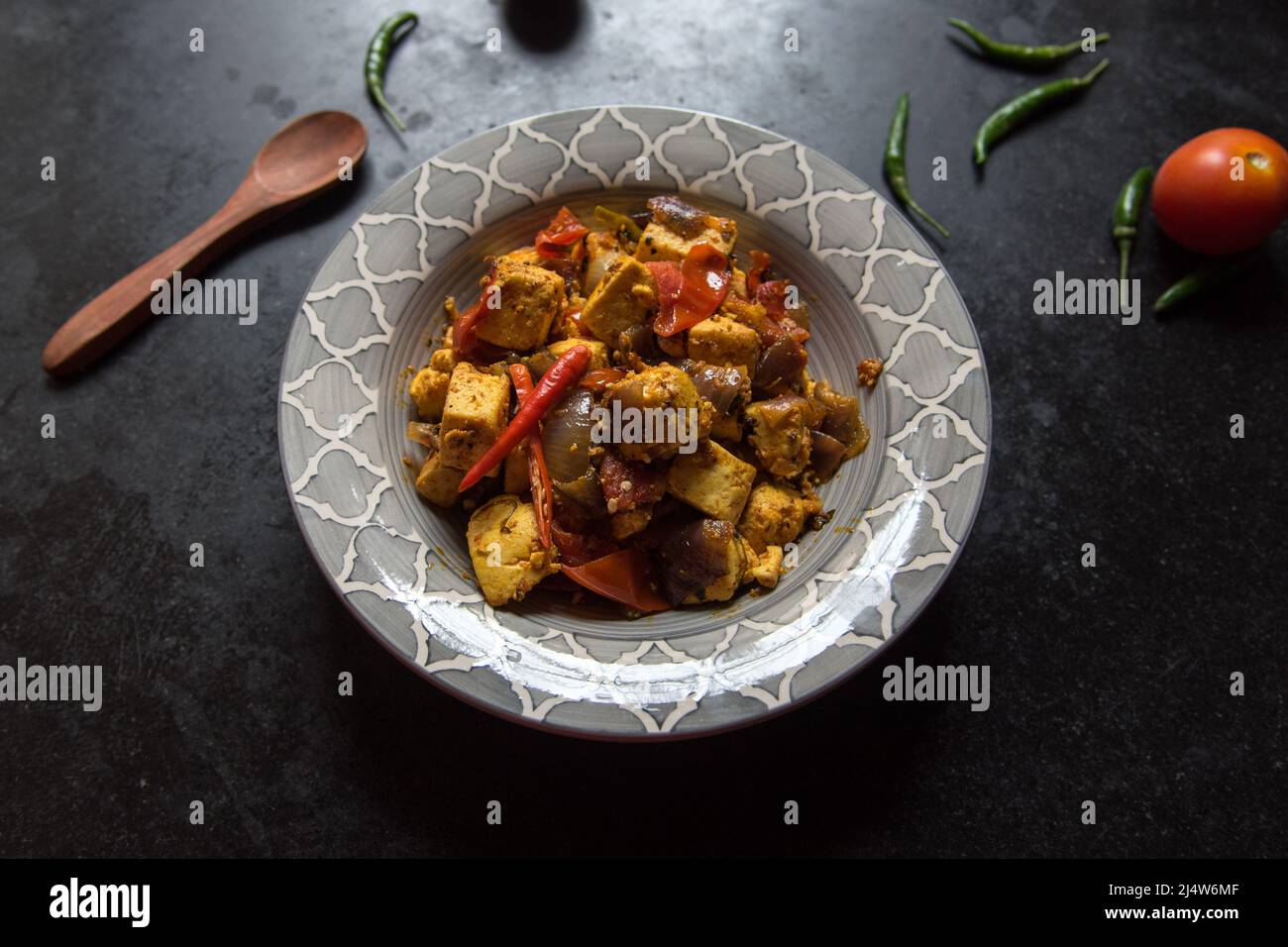 Beliebtes indisches Gericht Kadai Paneer oder Quark in einer Schüssel auf dunklem Hintergrund. Stockfoto