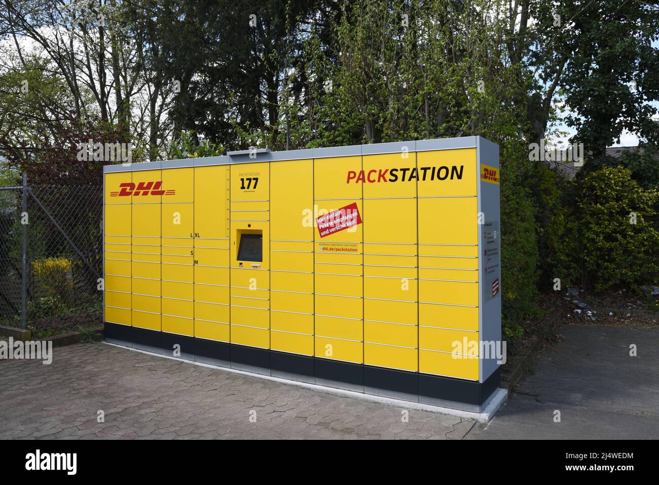 55286 Wörrstadt, 19. April 2022. Postpaketstation, die allein gegen die grüne Hecke steht Stockfoto