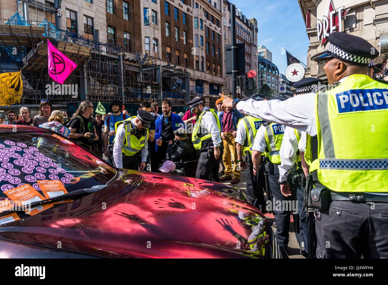 Die Polizei trifft auf ein blockiertes Auto mit roten Farbhanddrucken bei We will not be bystanders ein, ein Protest gegen das Aussterben der Rebellion, der für Klimagerechtigkeit kämpft, Stockfoto