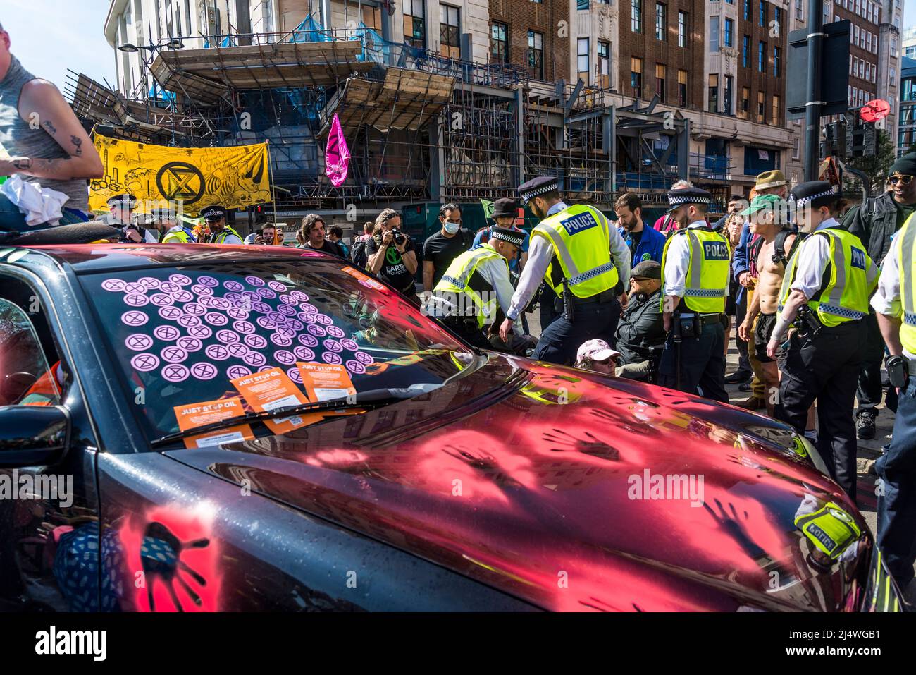 Die Polizei trifft auf ein blockiertes Auto mit roten Farbhanddrucken bei We will not be bystanders ein, ein Protest gegen das Aussterben der Rebellion, der für Klimagerechtigkeit kämpft, Stockfoto