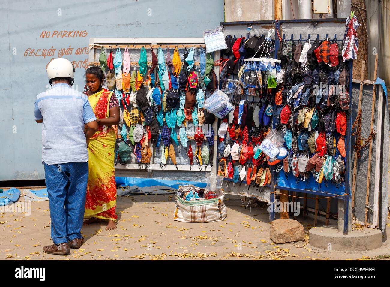 Frau, die bunte, selbstgemachte Stoffmasken in Trichy, Tamil Nadu, Indien verkauft Stockfoto