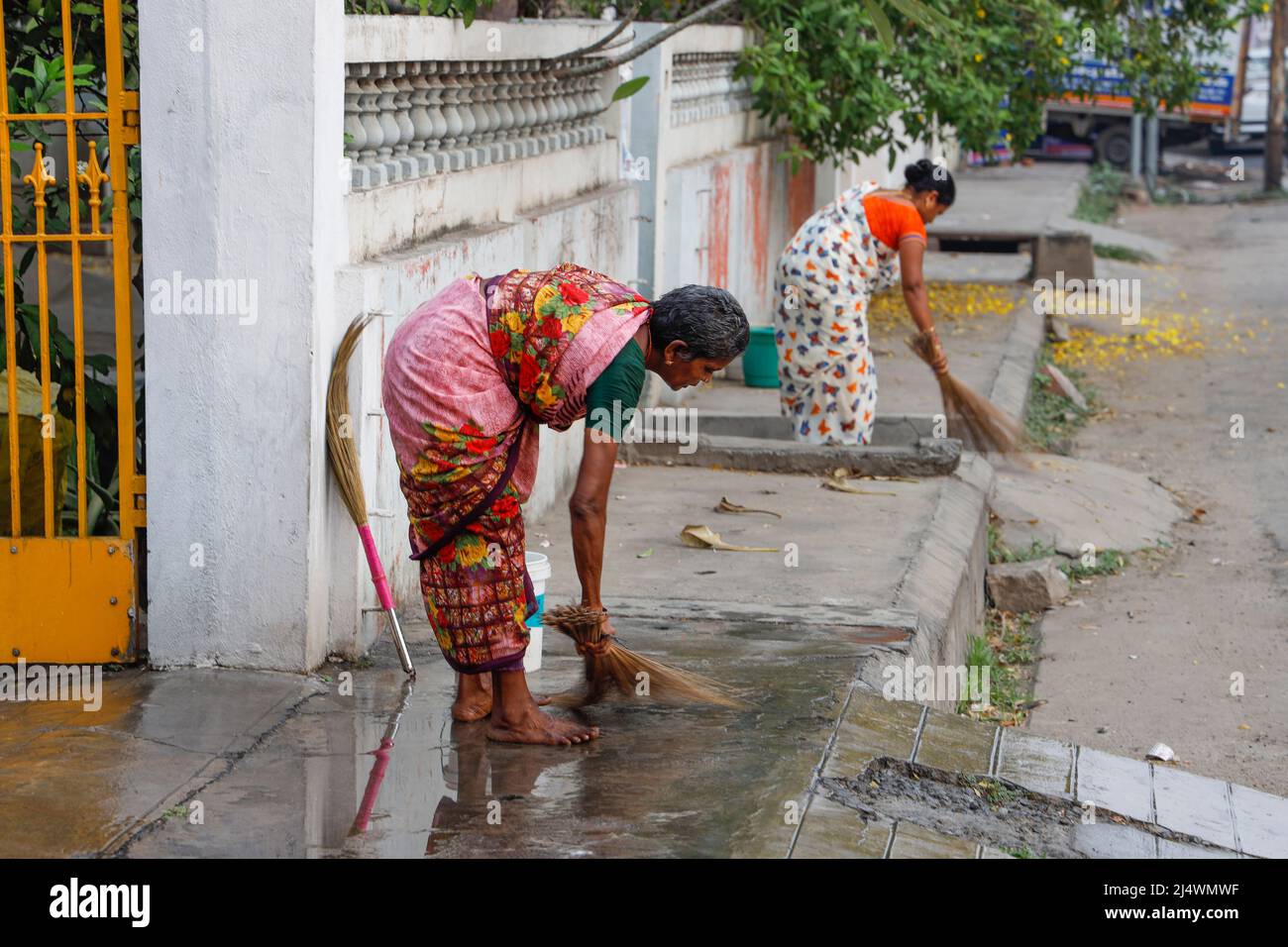Frauen putzen die Auffahrt früh am Morgen in Trichy, Tamil Nadu, Indien Stockfoto