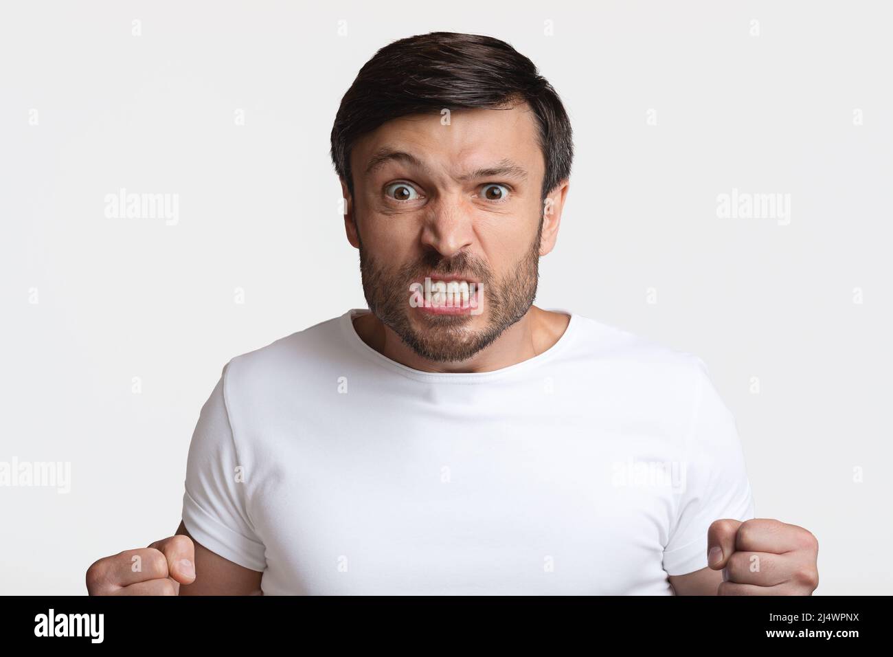 Furious Man: Fäuste In Rage Auf White Studio-Hintergrund Stockfoto