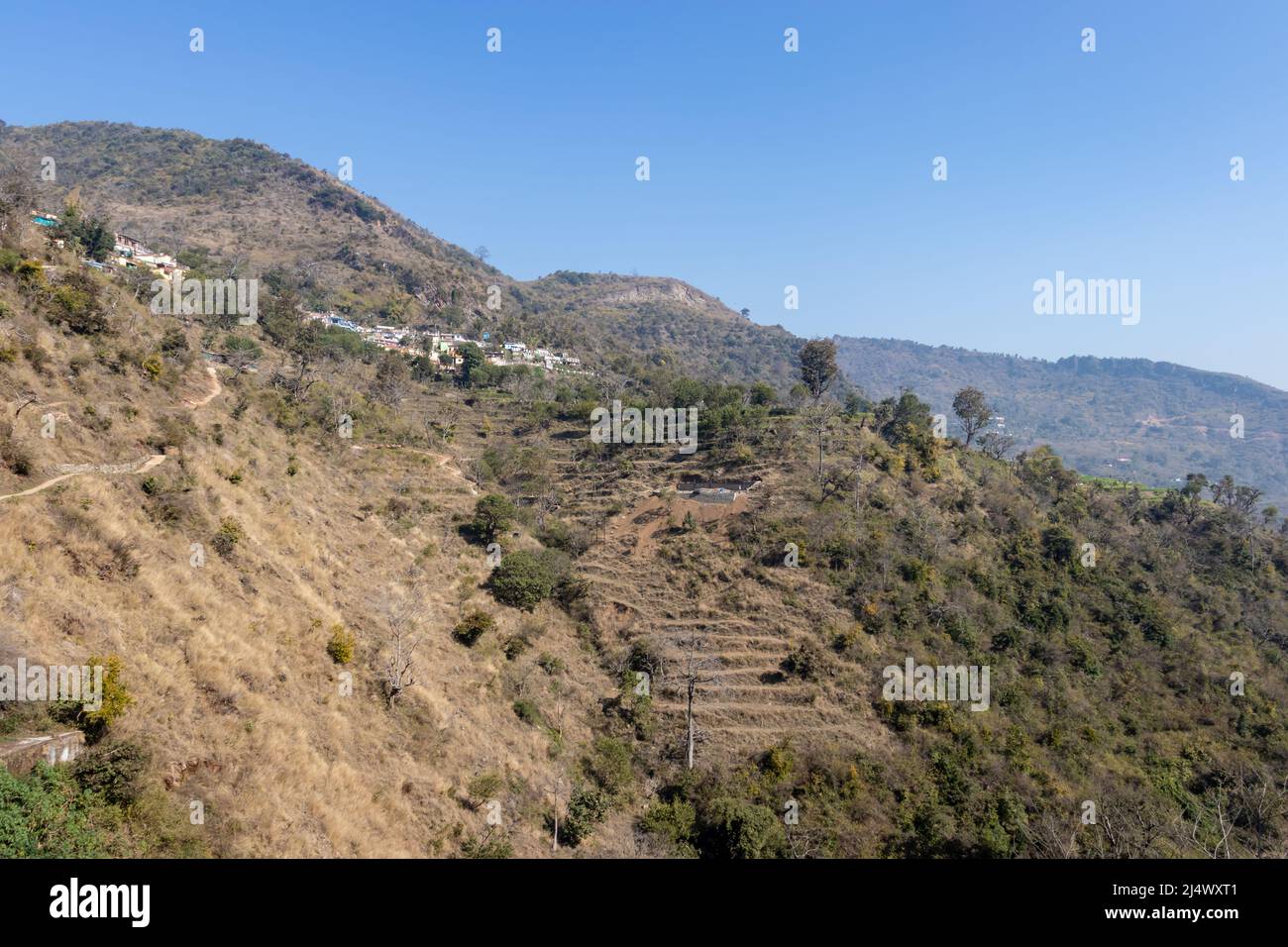 Kleines Dorf an Bergausläufern mit blauem Himmel am Morgen Bild wird bei neelkanth mahadev rishikesh uttrakhand indien aufgenommen. Stockfoto